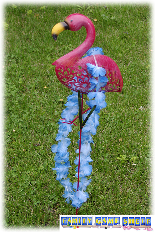 A flamingo with a flower lie around his neck