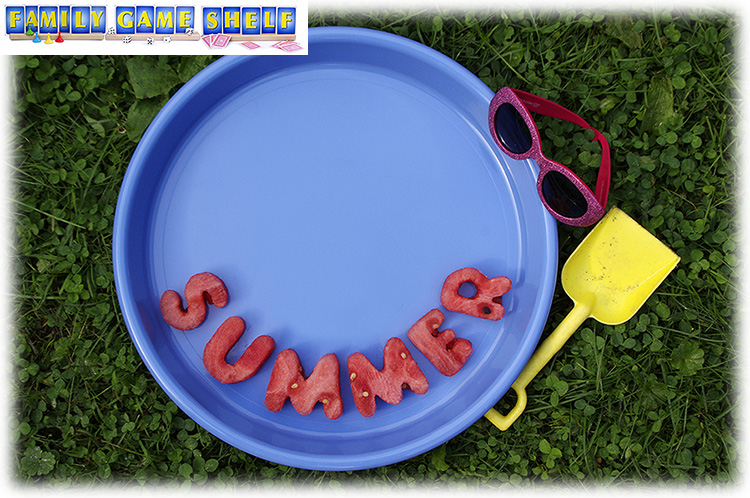 Watermelon cut into letters to spell summer with sunglasses and sand shovel