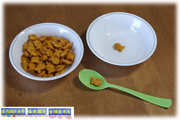 A bowl of Goldfish crackers with a plastic spoon