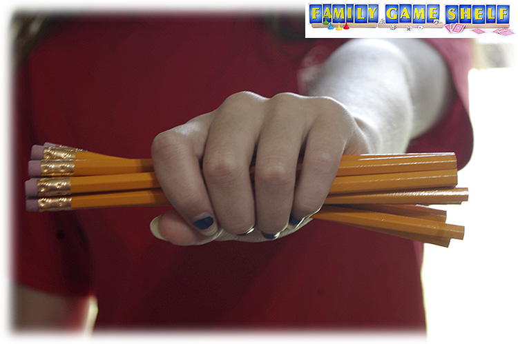 Hand gripping several yellow pencils for Pencil Grab Minute to Win it Back to School game