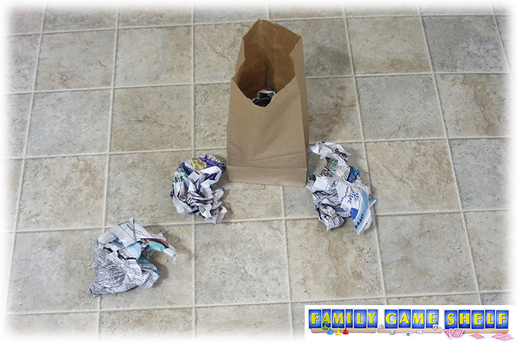 Brown paper lunch bag on floor with crumpled newspaper for minute to win it back to school