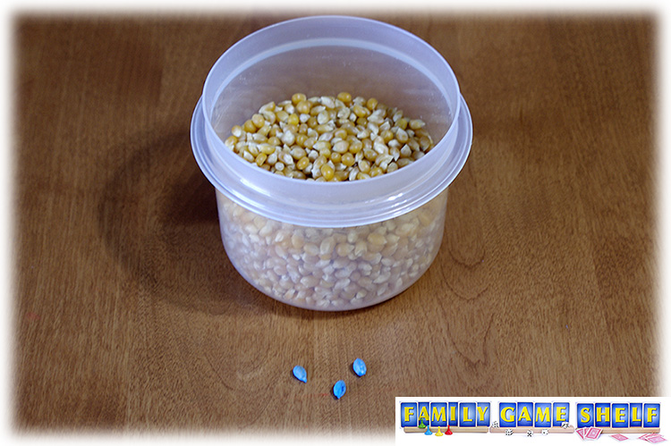 Bucket of popcorn seeds with three painted kernels