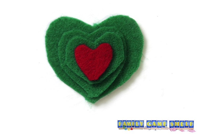 Grinch Party craft of three green felt hearts with a smaller red felt heart