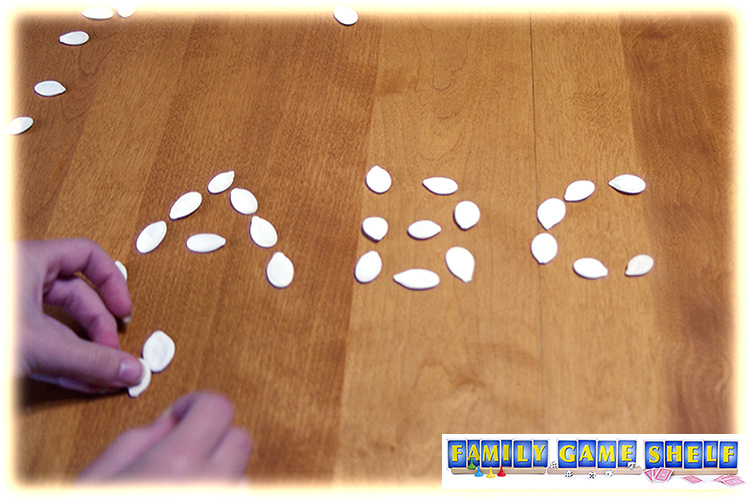 Pumpkin seeds on a table in letter shapes