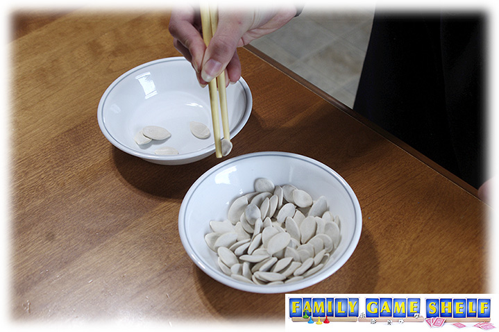 Pumpkin Seed minute to Win It games player with a seed in chopsticks 