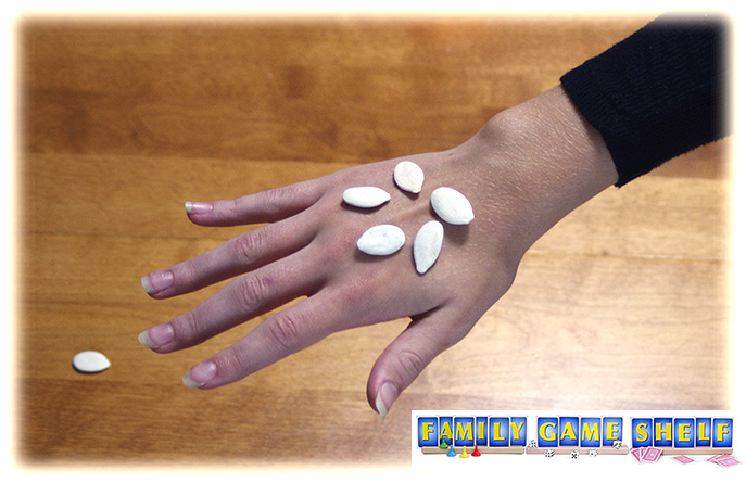 Pumpkin Seed Games player with five seeds on the back of her hand