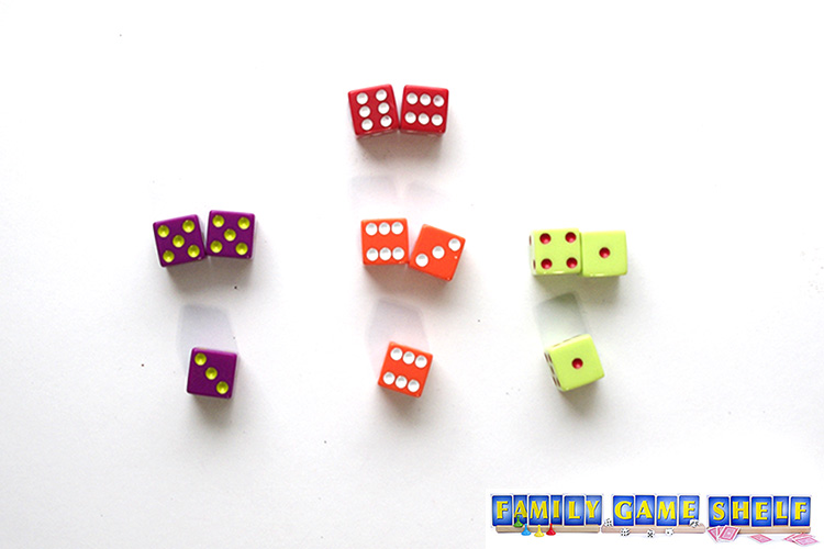 Dice Curling game with a target of 12. The purple plyer was 10 and the orange player rolls their third die to make 12 and wins the point