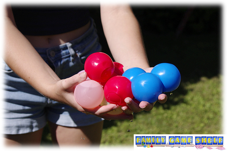Hands holding a bunch of water balloons