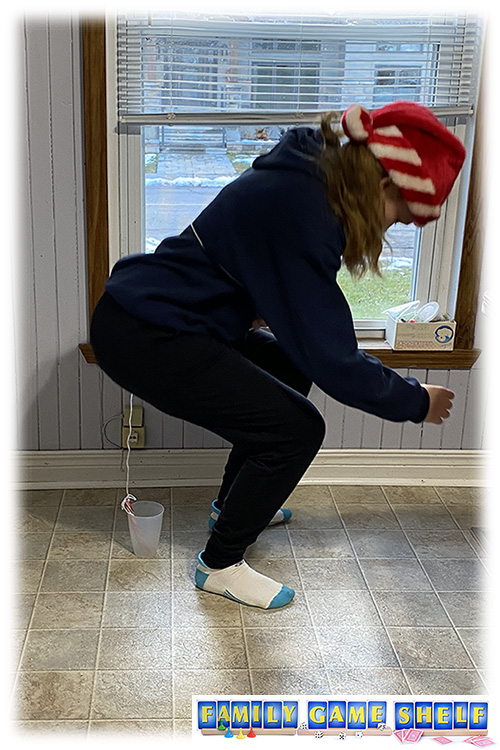 Don't Be Last Christmas player lowing a candy cane into a cup that is tied to her waist