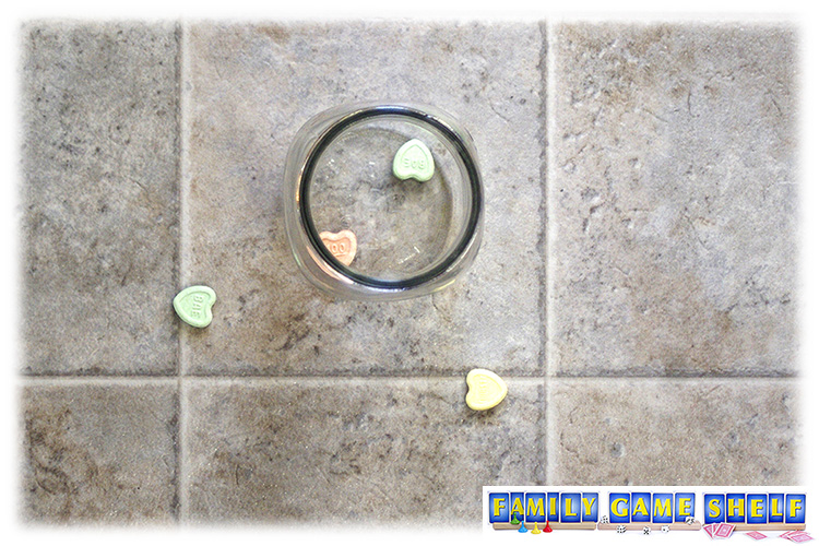 Candy hearts in and around a jar on the floor 