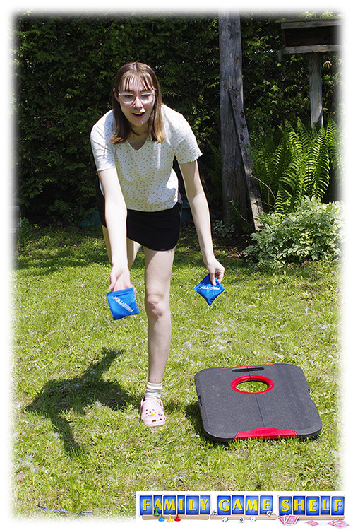 Cornhole Golf shot of a woman standing on one leg while throwing a bean bag