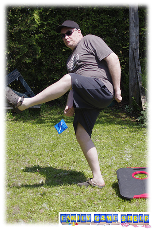 Cornhole Golf Trick shot of a man throwing a beanbag under his leg