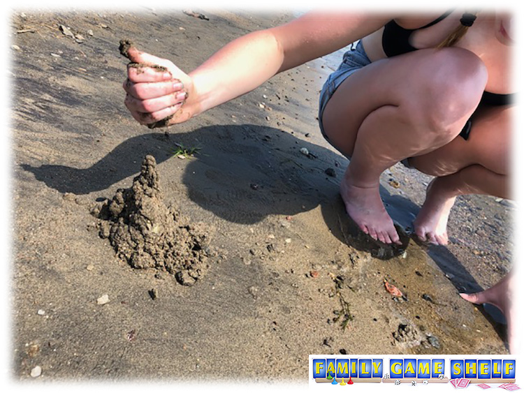 Best beach game showing a girl with sand dripping out of her hand to make a tower