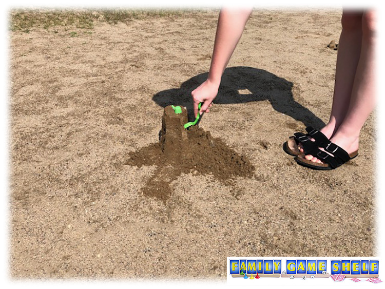 The best beach games a sand pile being cut with a plastic shovel showing the flour game