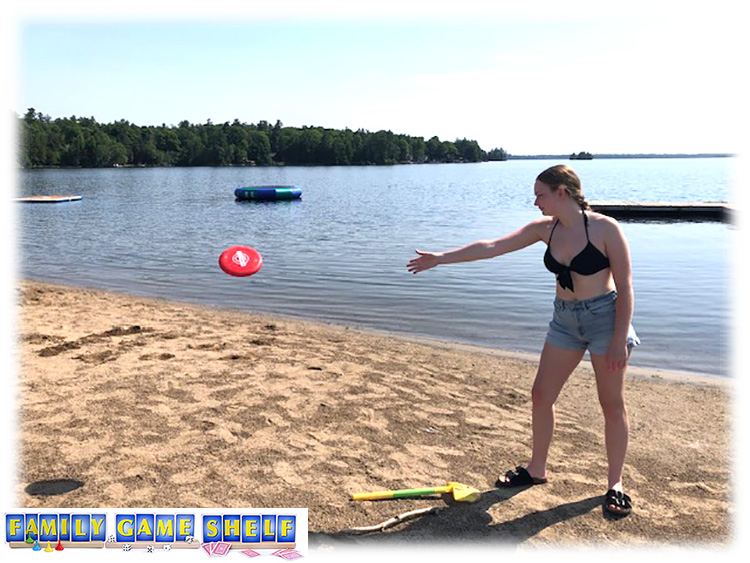 A girl throwing a frisbee on the beach