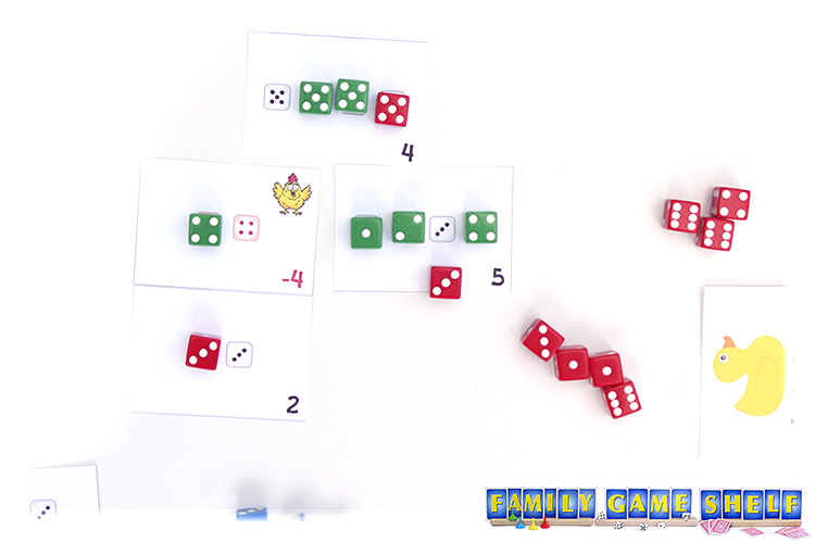 The red player has rolled a winning three and needs to pick between two cards